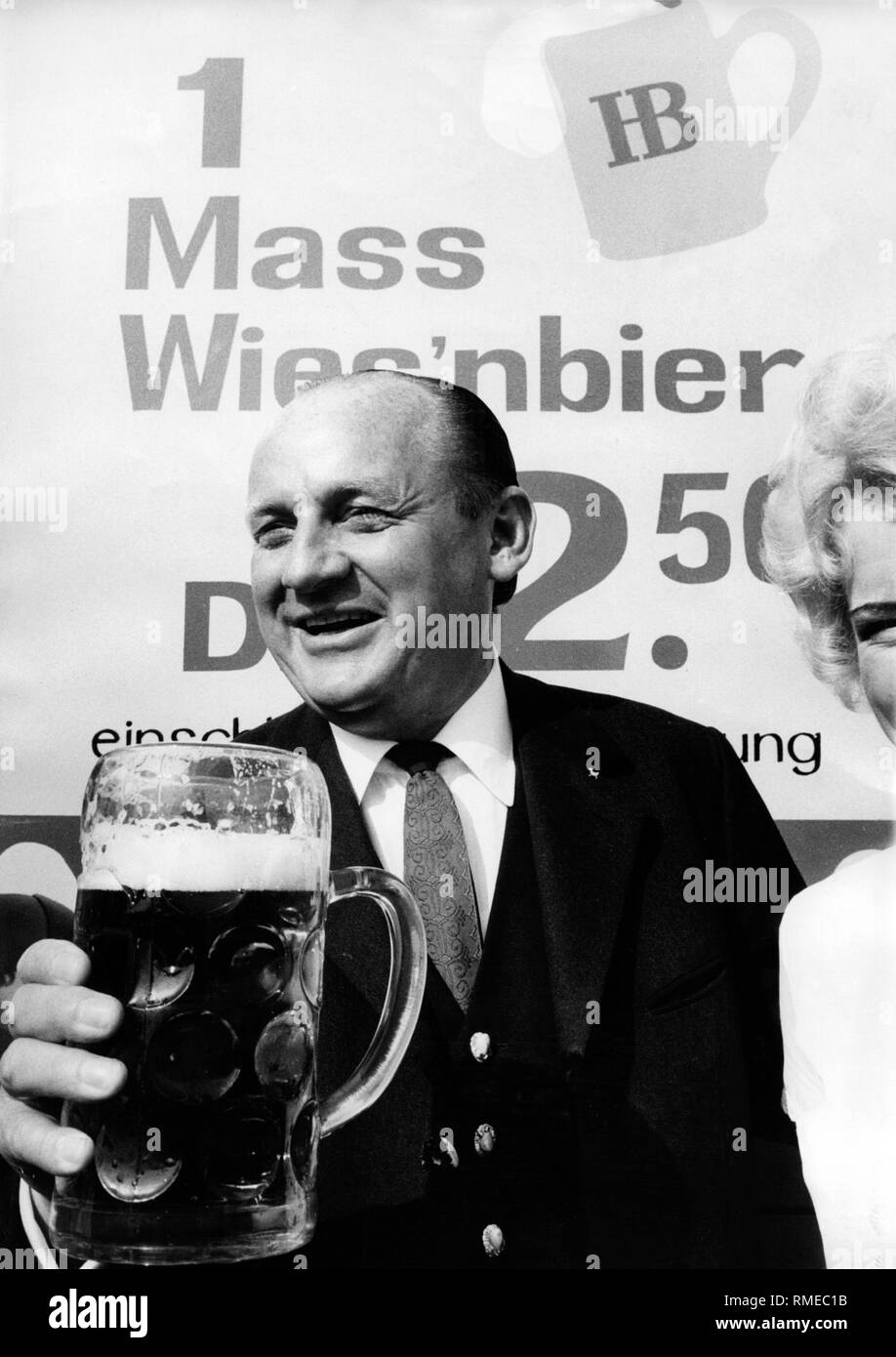 Friedrich Jahn, entrepreneur, Wienerwald, Autriche / Suisse, en face d'un signe qui annonce un litre de bière pour Hofbraeu DM 2,50 . Banque D'Images