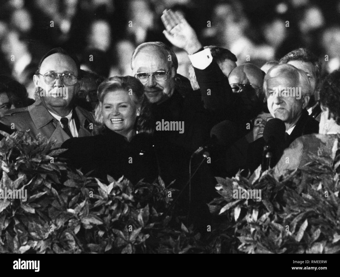 Le chancelier allemand Helmut Kohl (milieu) brandit à la population à Berlin le premier jour de congé officiel de la réunification allemande. Sur le côté gauche vous pouvez voir sa femme Hannelore, alors ministre d'état des affaires étrangères Hans-Dietrich Genscher, sur le côté droit, il y a Richard von Weizsäcker. Banque D'Images