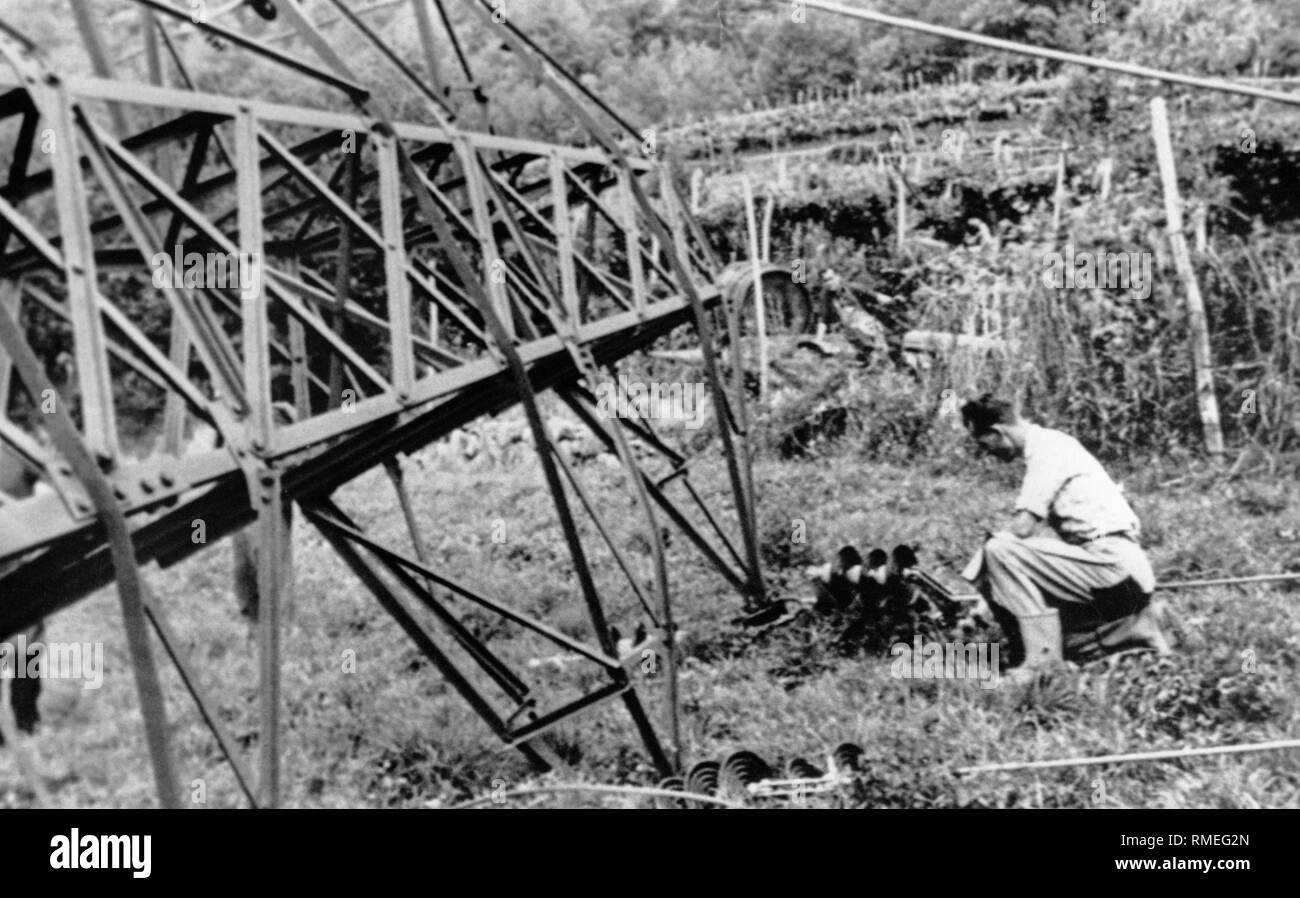 Attentat sur une ligne à haute tension à l'Guntschna promenade près de Bolzano. Des militants du Comité de libération sud-tyrolien (BAS) perpétré de nombreux attentats à la bombe dans le sud du Tyrol en 1961. En juin 1961, ces actions ont abouti à la "Nuit du Feu". En une seule nuit, 37 poteaux électriques ont été dynamités. Les explosions étaient destinées à paralyser l'approvisionnement énergétique de la zone industrielle de Bolzano, qui était un projet modèle pour la tentative d'Italianization pendant le fascisme. Banque D'Images