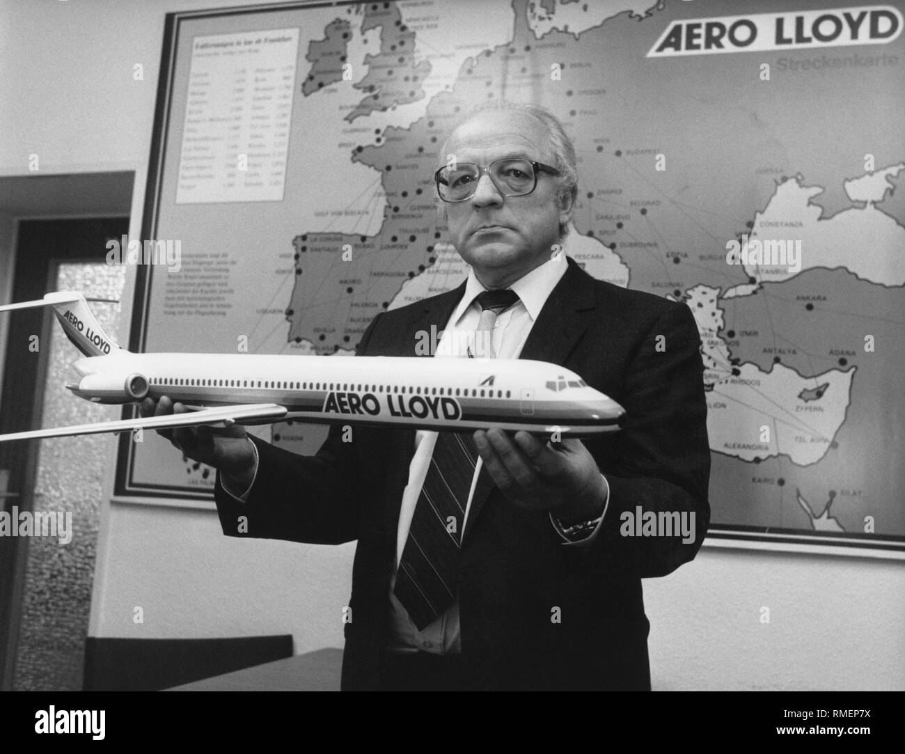 Walter Schneider, directeur général de la compagnie aérienne allemande Aero Lloyd avec un modèle d'un McDonnell Douglas MD-83 en face d'une carte d'itinéraire de sa compagnie aérienne. L'Aero Lloyd a existé de 1980 à 2003, et a fonctionné principalement dans la charte. Banque D'Images