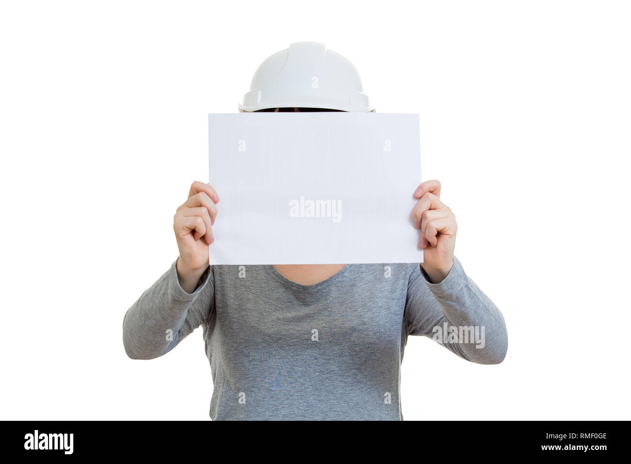 Jeune femme portant des ingénieur casque, tenant une feuille de papier vierge couvrant son visage isolé sur fond blanc. Banque D'Images