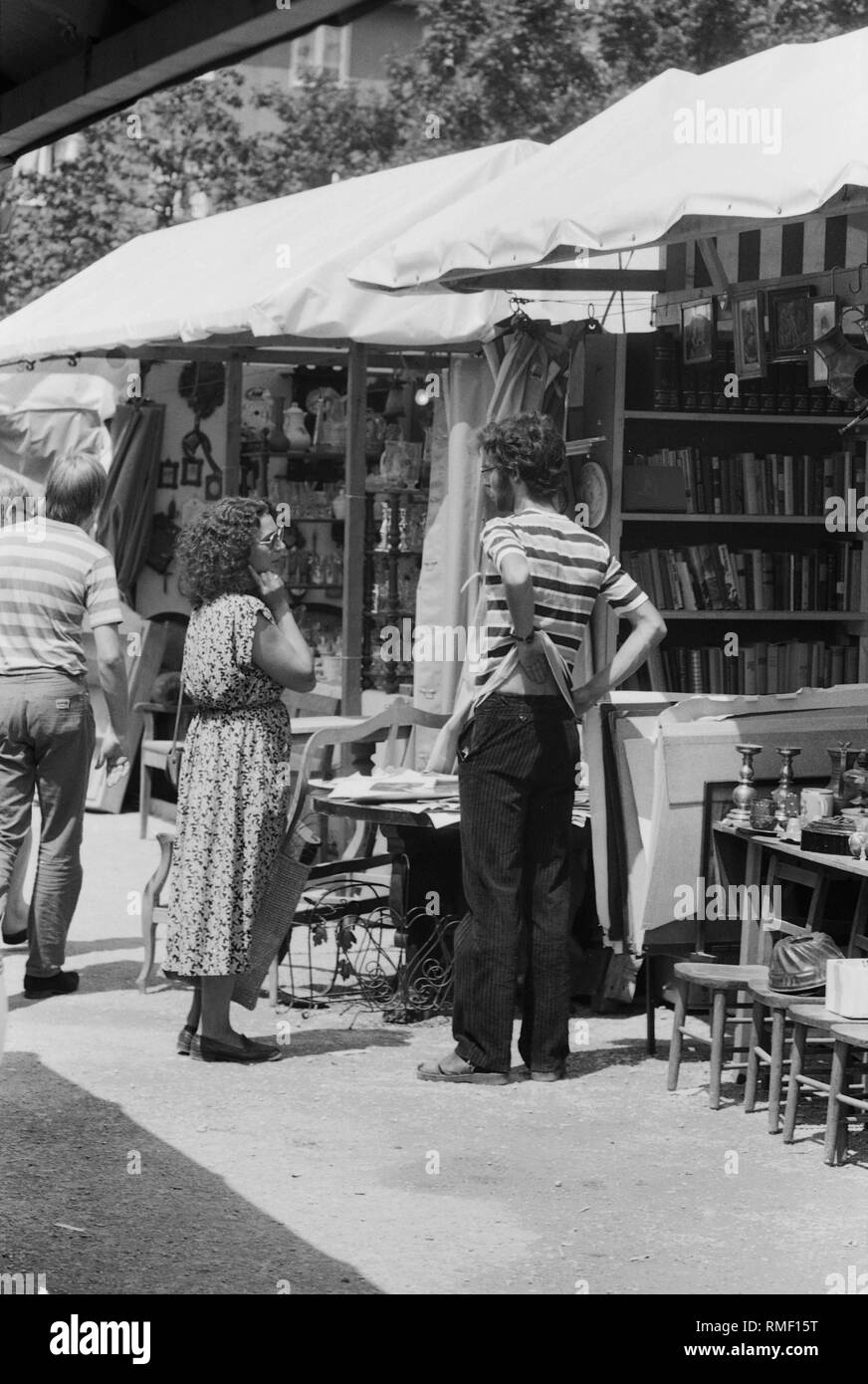 Un vendeur d'une échoppe de marché à Auer Dult à Munich en conversation avec un client. Banque D'Images