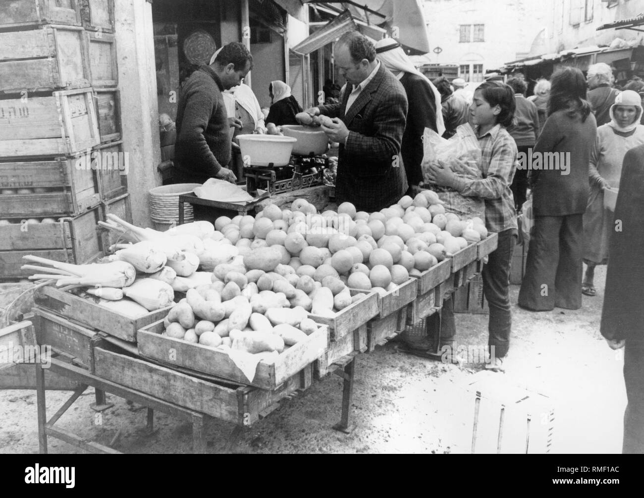 Vendeur avec les clients à un kiosque de légumes sur un marché à Nazareth. Banque D'Images