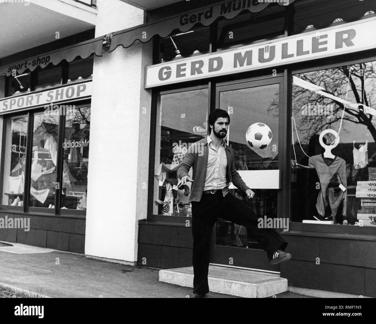 Gerd Mueller joue avec un ballon de football en face de son magasin d'articles de sport dans la région de Aschau dans les années 70. Banque D'Images