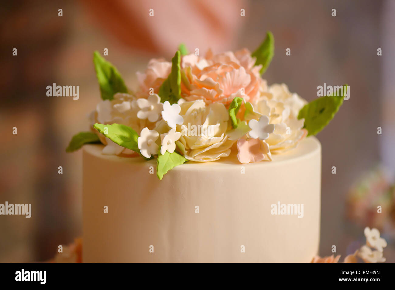 Formelle élégante gâteau à plusieurs niveaux avec le Haut joliment décoré de sucre glace fleurs et recouvert de glaçage royal velouté préparé pour un mariage Banque D'Images