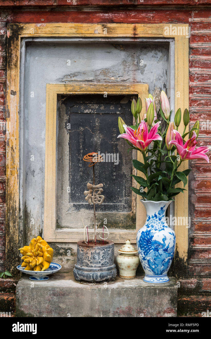 Autel bouddhiste avec des fleurs, des fruits et d'insectes du bois, Hanoi, Vietnam Banque D'Images