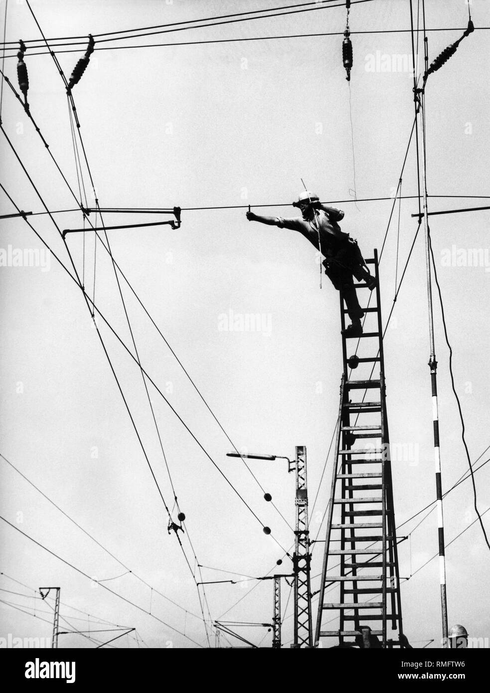 Un électricien travaillant sur les câbles électriques sur la voie ferrée. Banque D'Images