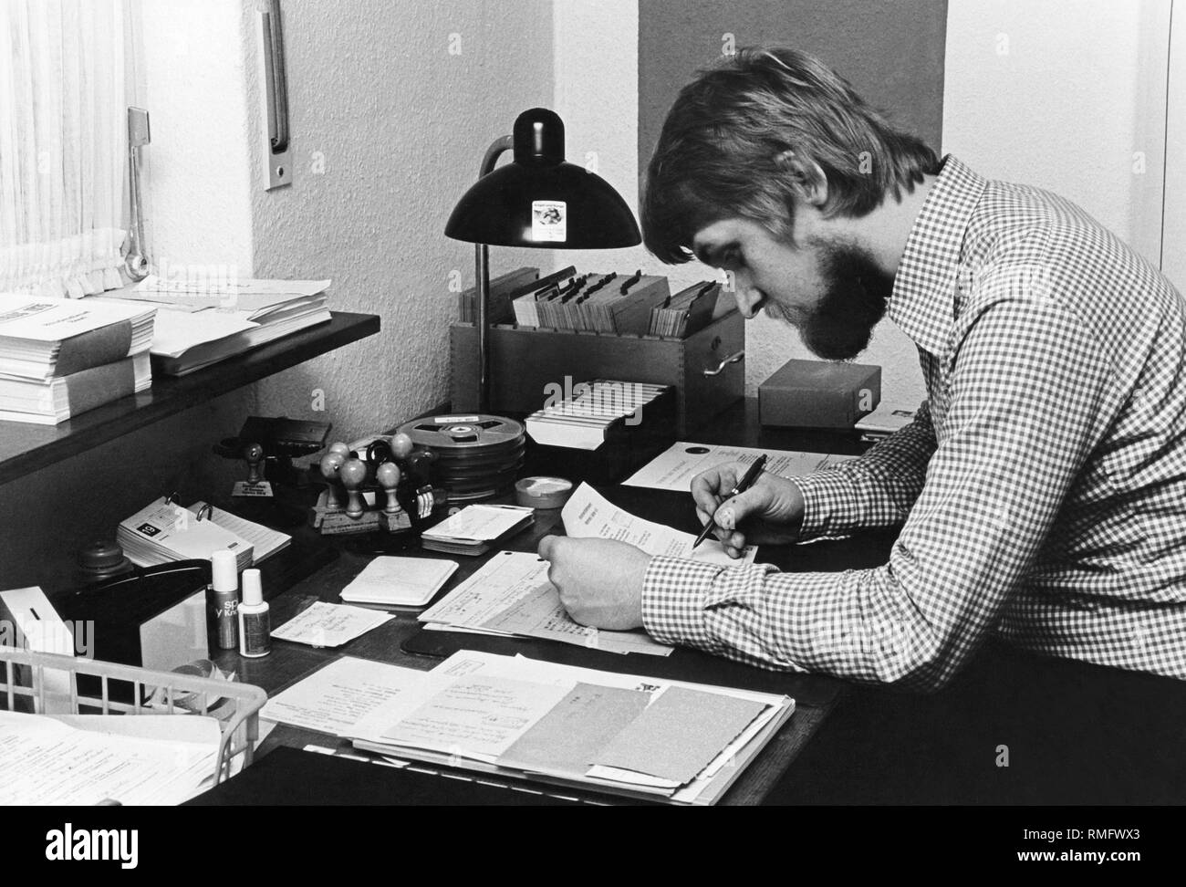 Employée de bureau se trouve au bureau et travaille. Banque D'Images