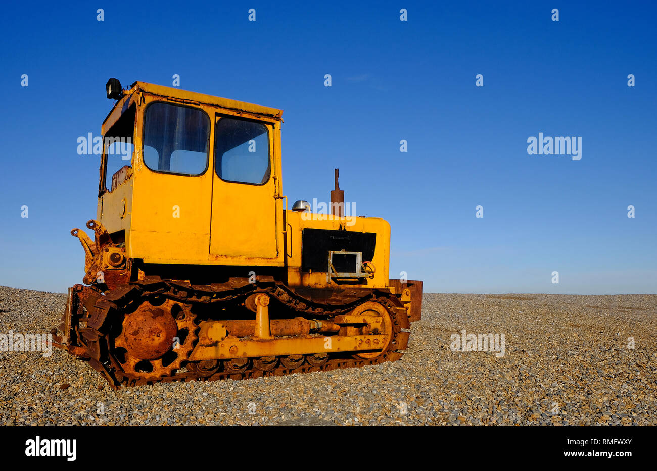 Tracteur jaune rouillé sur weybourne beach, North Norfolk, Angleterre Banque D'Images