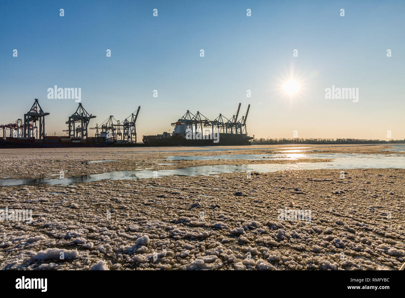 Grues de déchargement dans le port avec de la glace et de la neige en hiver Banque D'Images