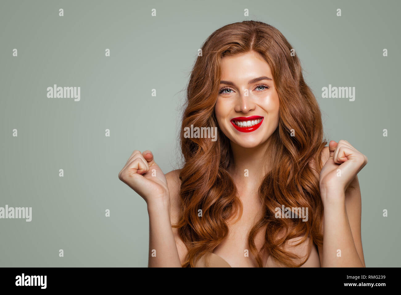 Tête rouge et brillante fille avec de longs cheveux bouclés. Heureux surpris femme. Les expressions du visage expressif Banque D'Images