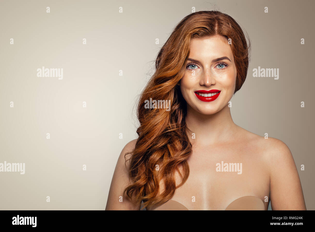 Portrait de femme rousse heureux. Tête rouge élégante fille avec curly hairstyle smiling Banque D'Images