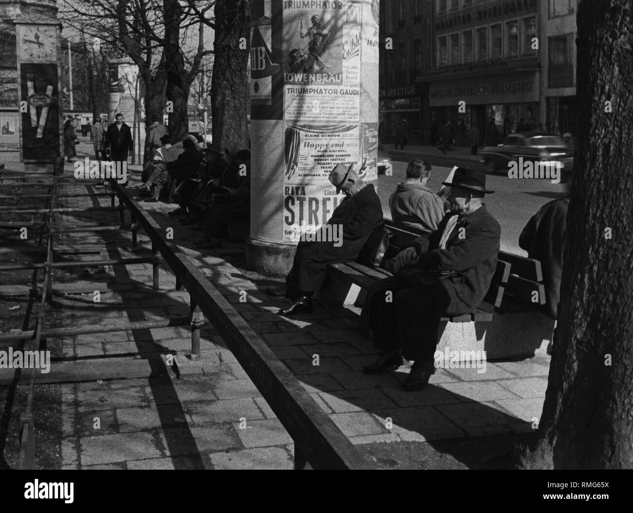 Les gens sur les bancs de soleil au bord de la Stachus à Munich. Banque D'Images