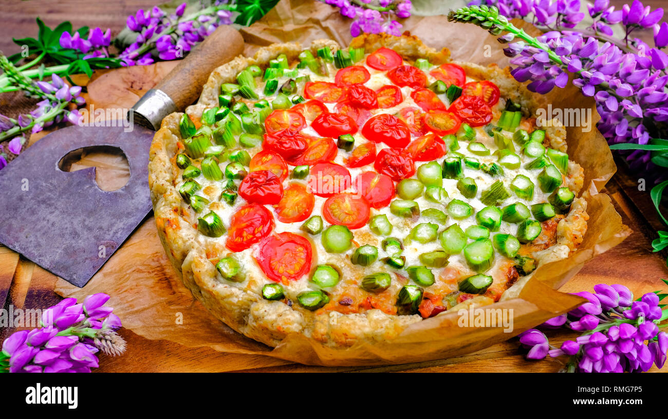 Tarte aux tomates et d'asperges. La nourriture pour les légumes frais et d'herbes. Table d'été Style avec lupins Banque D'Images