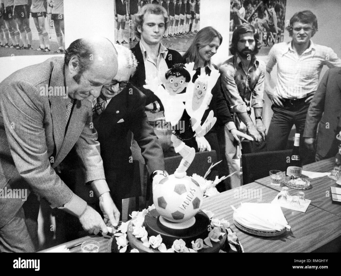 Entraîneur de football Helmut Schoen (à gauche) reçoit un gâteau d'anniversaire de Adi Dassler, chef de l'entreprise Adidas (2e de gauche) avec un football Adidas au Salon International des Articles de sport à Cologne (SPOGA). À côté de Dassler stand Uli Hoeness, Heide, Rosendahl-Ecker Gerd Mueller et Sepp Meier (de gauche) et attendre un morceau de gâteau. Banque D'Images
