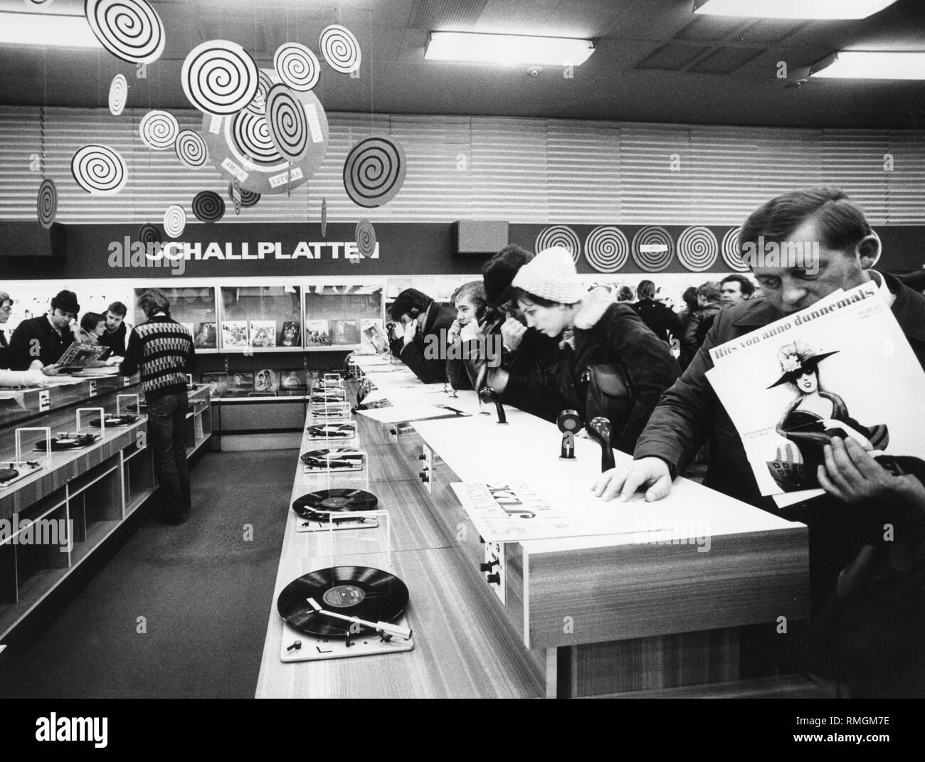 Photo non datée d'un enregistrement dans un ministère est de Berlin Centrum magasin de la Handelsorganization ( ?Trading organisation ?) de la RDA. Les clients d'écouter des enregistrements. Au premier plan un enregistrement par le Ballhausorchester Kurt Beyer 'Hits von dunnemals anno'. Banque D'Images
