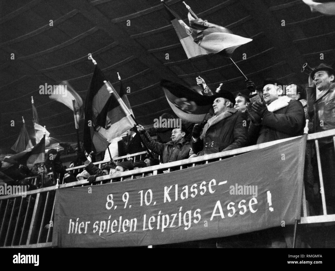 1.FC Lok Leipzig partisans pendant les seize match en Coupe de l'UEFA contre Fortuna Düsseldorf à Düsseldorf. Le Fortuna a gagné avec 2-1. Les fans tenir le club des drapeaux dans les mains. En face d'eux est une bannière avec l'inscription : 'Classe 8.9.10 - ici la lecture de l'aces Leipzig !'. Banque D'Images