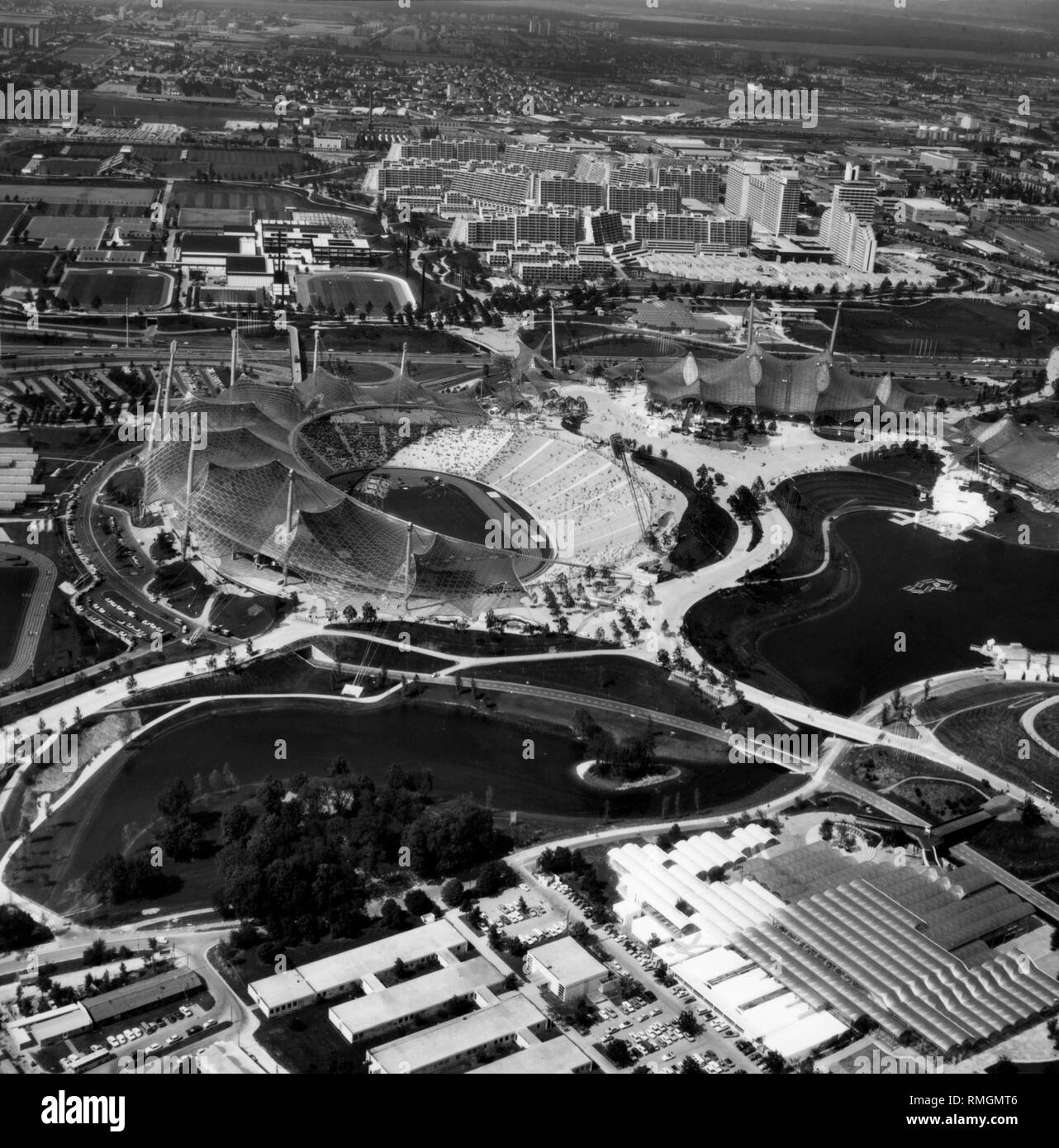 Vue sur le parc olympique de Munich, où le Jeux Olympiques d'été de 1972 a eu lieu. Au milieu du stade olympique, à droite le Coubertinplatz, Olympiahalle, piscine olympique et Olympiasee lake. Derrière elle la Zentrale Hochschulsportanlage et le Village Olympique. Au premier plan à droite, le restaurant a poursuivi, sur la gauche l'Olympische Baugesellschaft (entreprise de construction Olympique). Banque D'Images