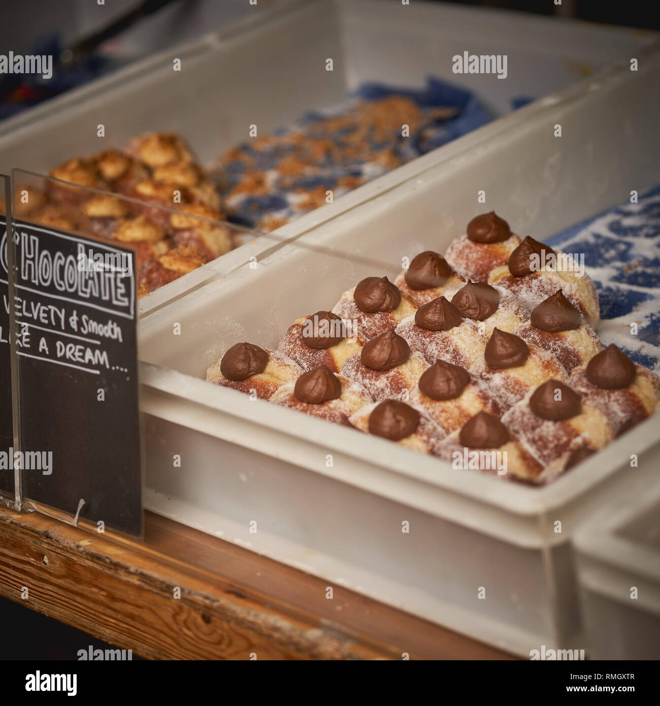 Variété de donuts rempli de crème au chocolat et beurre d'arachide à la vente à un décrochage de boulangerie dans un marché local. Format carré. Banque D'Images