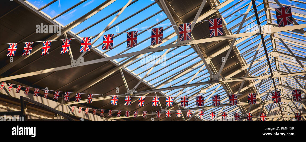 Royaume-uni les drapeaux sur un fil suspendu à une toiture d'acier avec des lucarnes. Format panoramique. Banque D'Images
