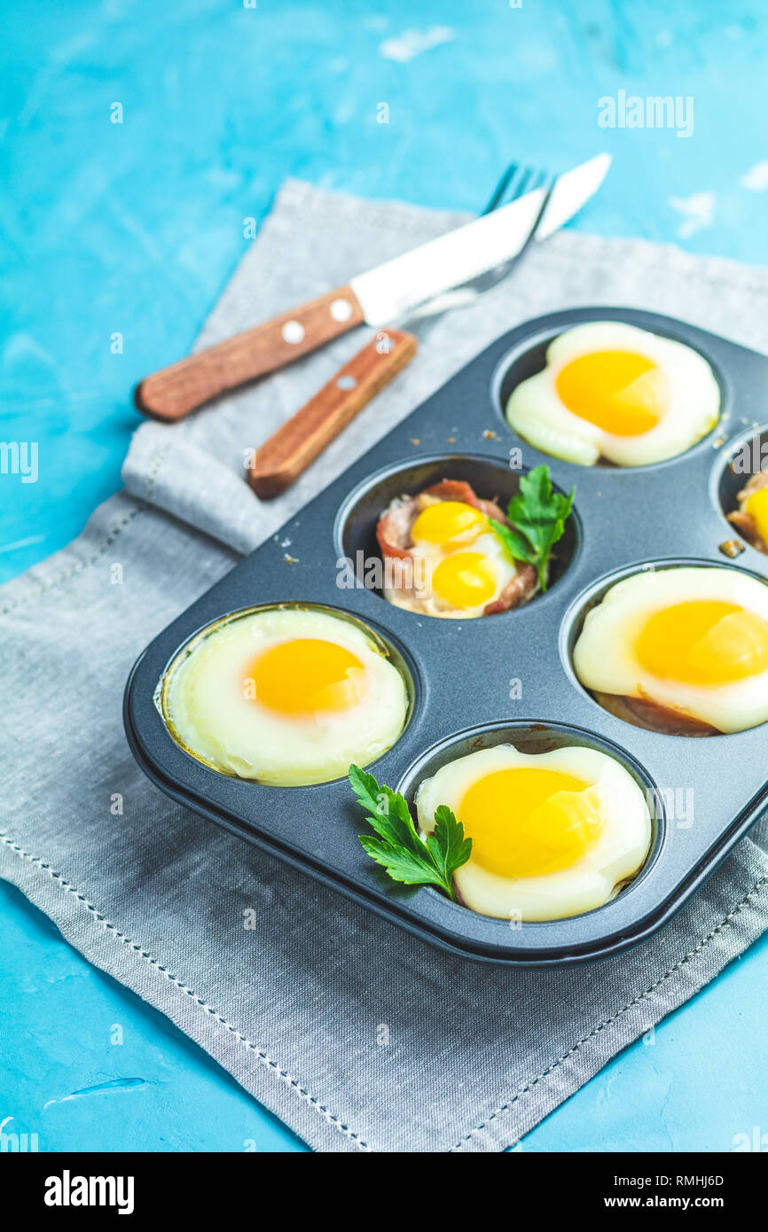 Les œufs cuits dans la cuisson des moules. Cassolette de bacon sowbelly portionné et oeufs dans le style italien. Banque D'Images
