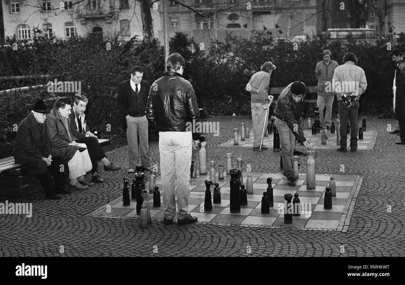Les hommes jouent aux échecs sur un parc au Muenchner Freiheit à Munich, mars 1986. Banque D'Images
