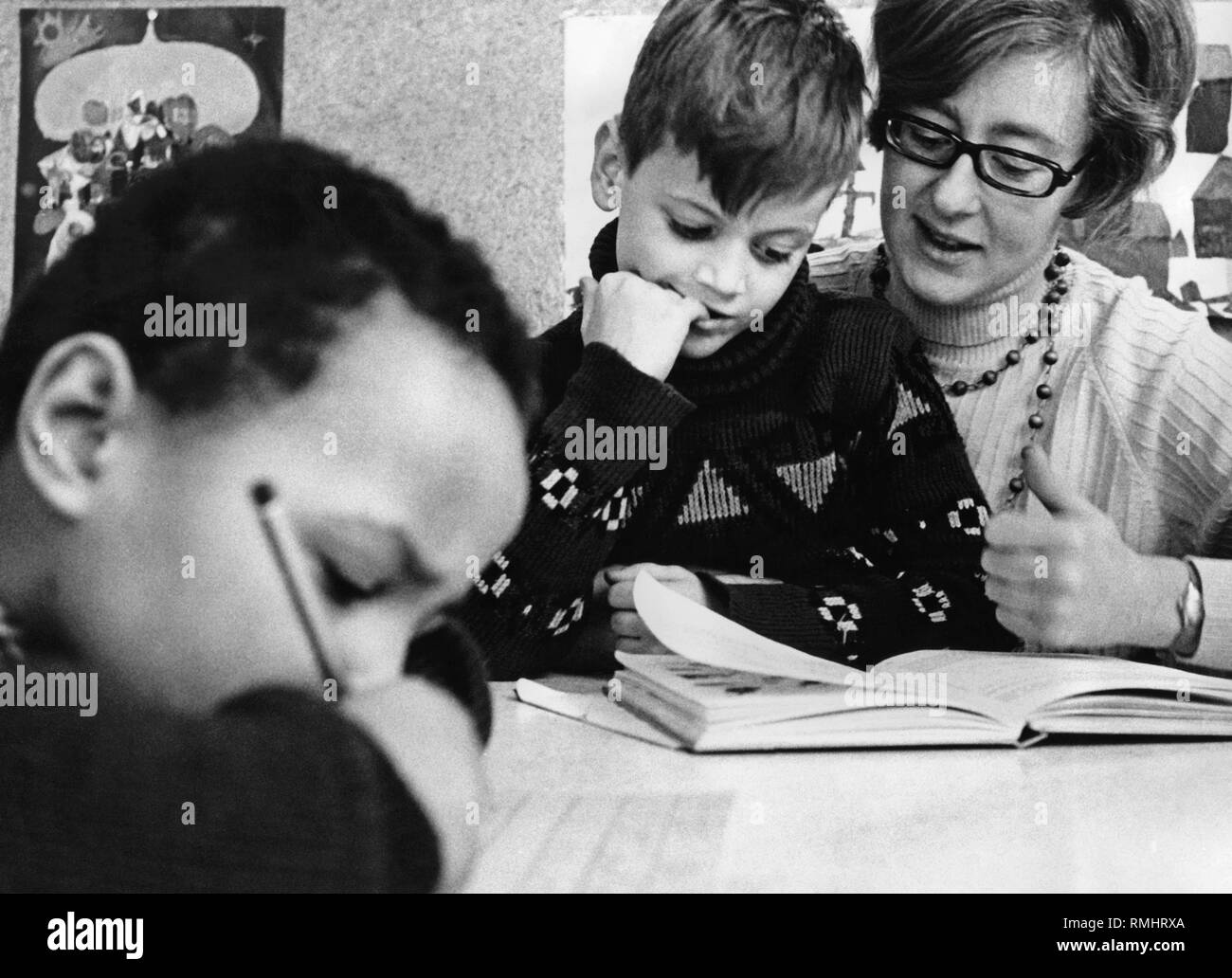 Les enfants à l'école : photo montre avec l'enseignant les enfants à faire leurs devoirs. Banque D'Images