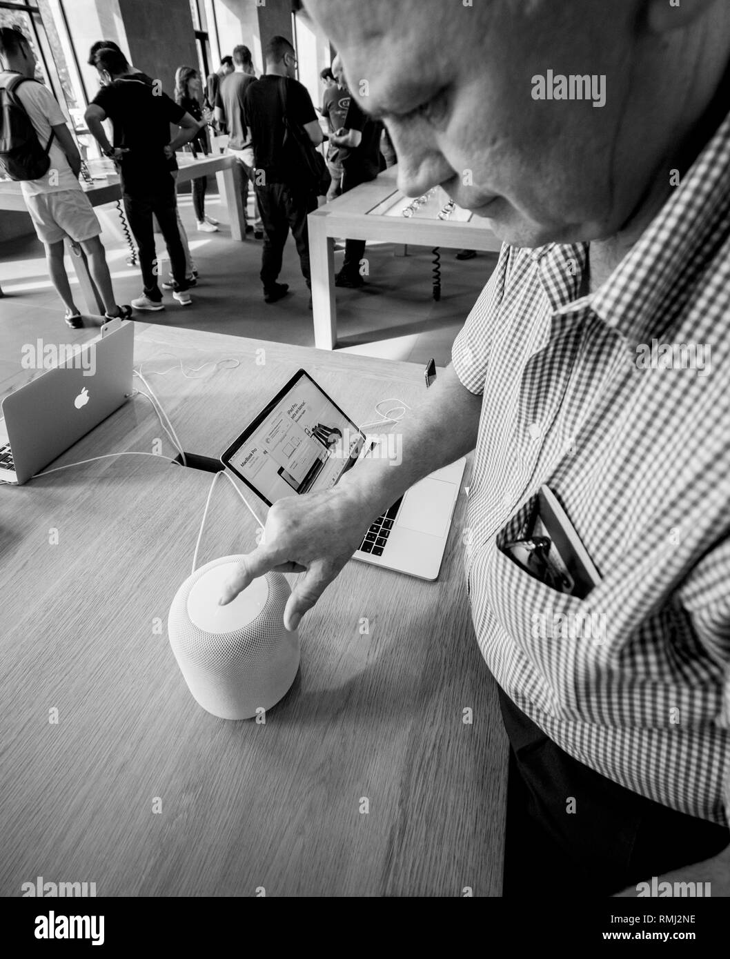 STRASBOURG, FRANCE - Sep 21, 2018 : senior man curieux le HomePod test smart speaker dans Apple Store au cours de l'iPhone Xs et Xs Max preorder pour Xr et regarder des séries 4 wearable smartwatch - noir et blanc Banque D'Images