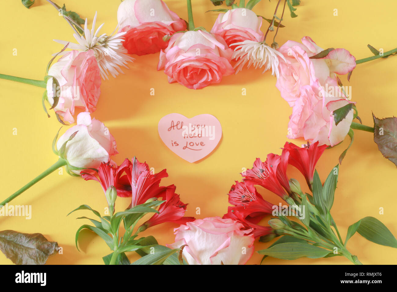 Arrangement de fleur avec l'écriture mignon sur un coeur Banque D'Images
