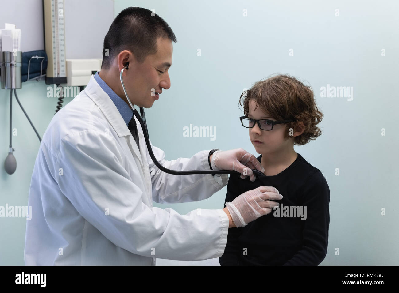 Young Asian male doctor examining Young boy patient avec stéthoscope dans clinic Banque D'Images