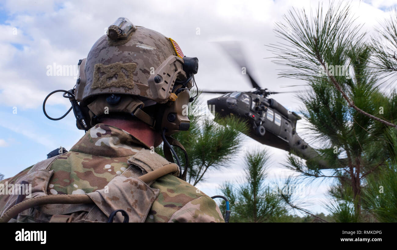 La Marine américaine une mer, air et terre (SCEAU) attend des membres de l'équipe extraction d'un UH-60 Black Hawk pendant une émeraude Warrior 2019 Exercice de formation de recherche et de sauvetage, le 22 janvier 2019. Opération tactique spéciale a travaillé aux côtés des joints de la finale de l'attaque conjointe d'extraire les contrôleurs blessés et crénelé joint force les membres de l'équipe dans un environnement austère. (U.S. Air Force photo par un membre de la 1re classe Scott Warner) Banque D'Images