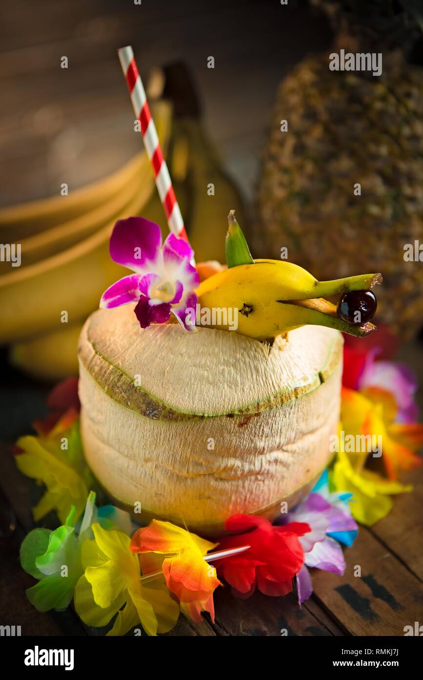 Tiki Funky cocktail servi dans un ananas frais avec une banane dolphin garnir Banque D'Images