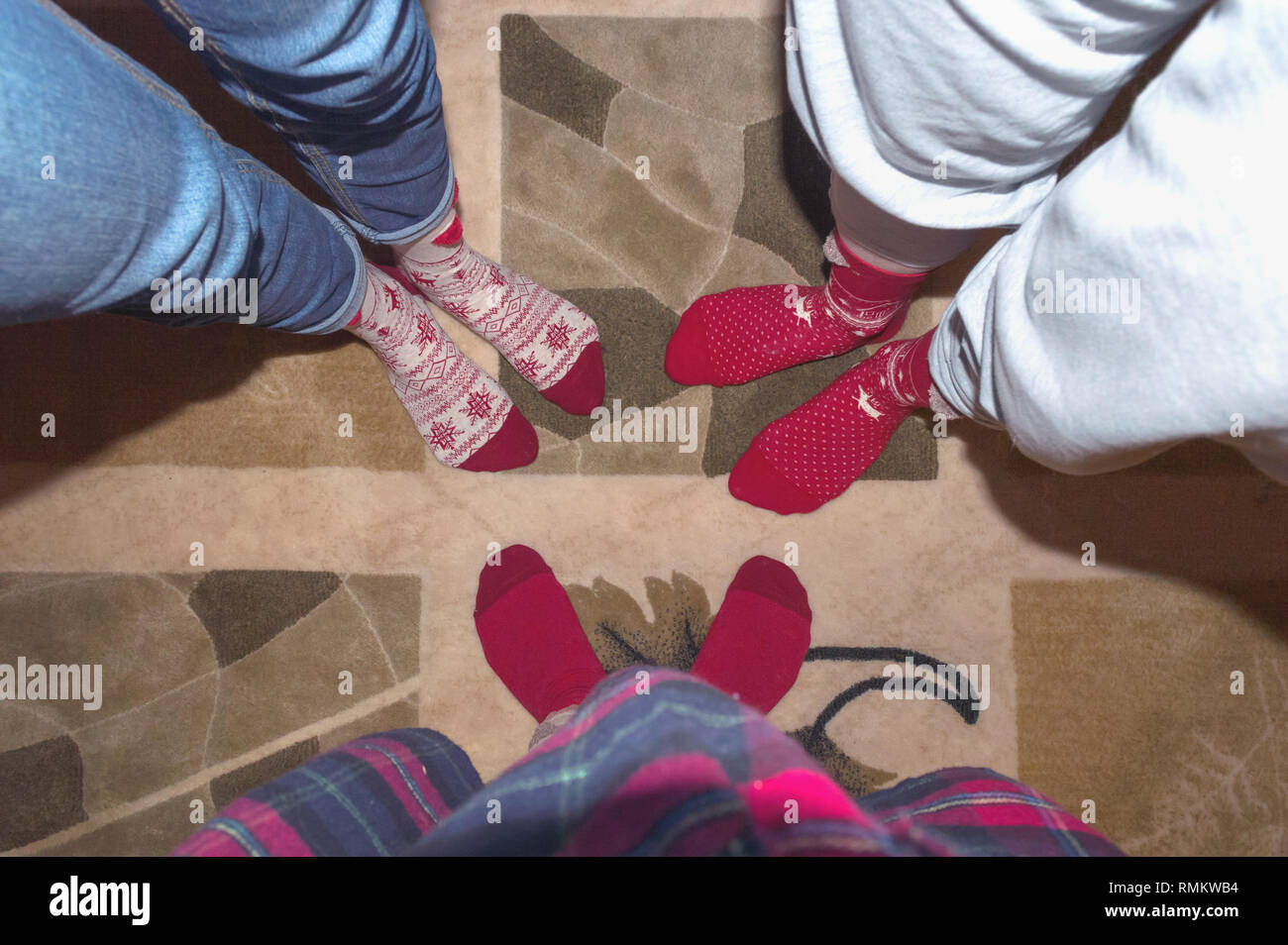 Image drôle d'amis jambes en rouge maison de chaussettes sur le tapis Banque D'Images