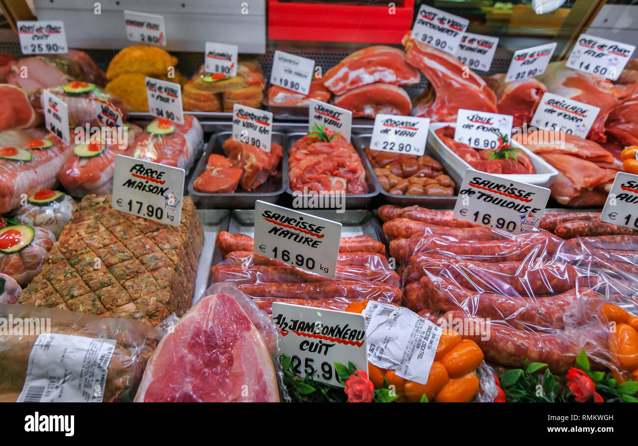 Afficher le comptoir d'une boucherie française typique avec différents types de viande, jambon, saucisses, joues de porc, reins de veau, et autres produits de viande Banque D'Images