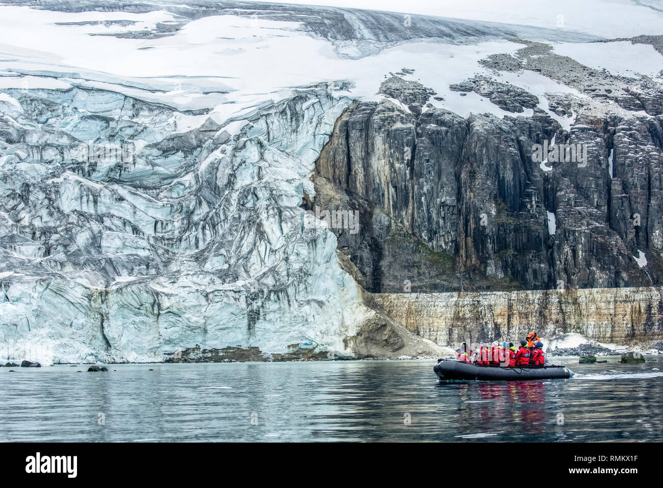 Les passagers de croisière aventure sur un zodiaque en caoutchouc tour lugubre un iceberg au Spitzberg, Norvège en juin Banque D'Images