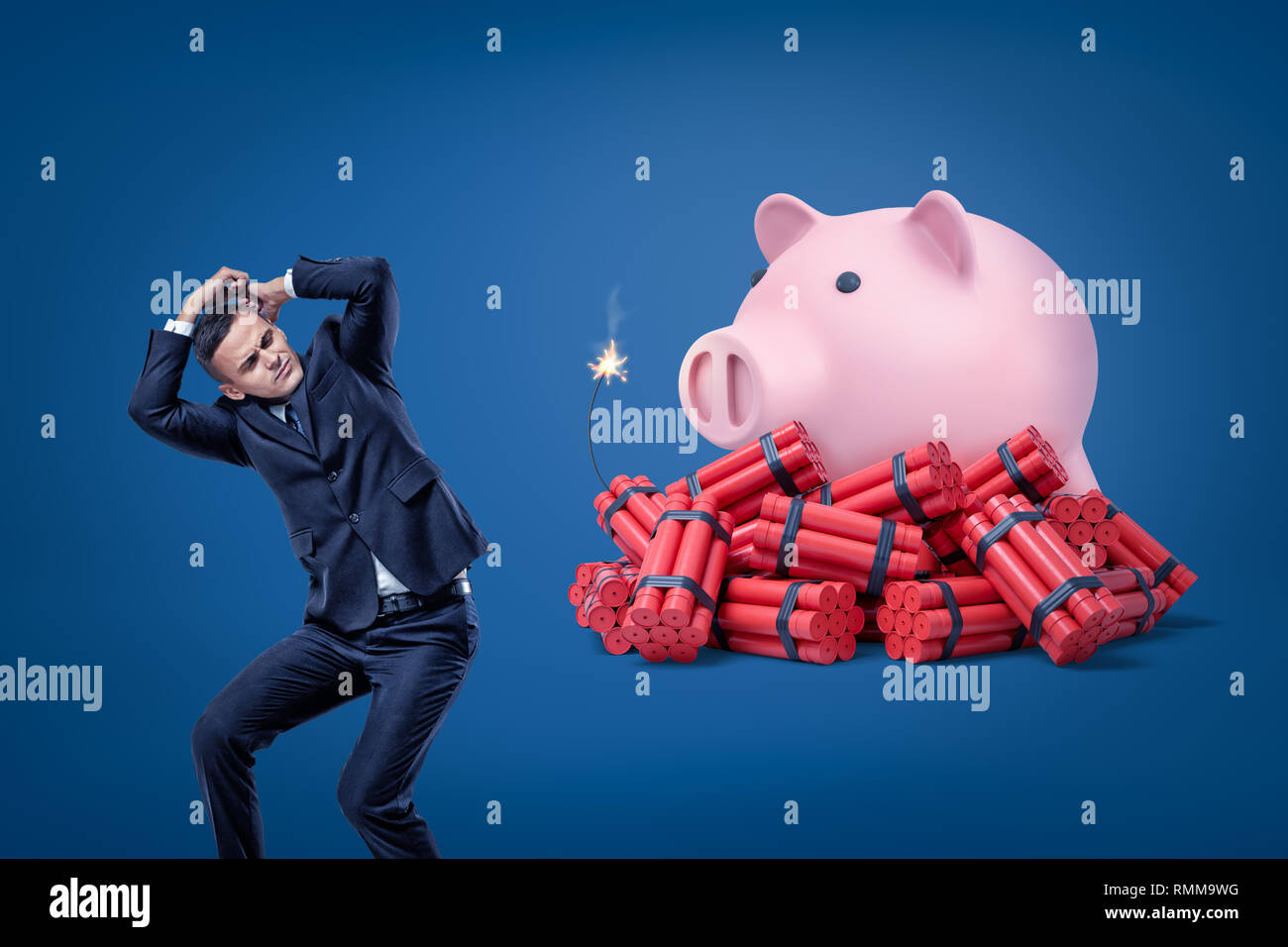 Businessman se protéger avec les mains et pink piggy bank sur rouge bâtons de dynamite avec fusible sur fond bleu Banque D'Images