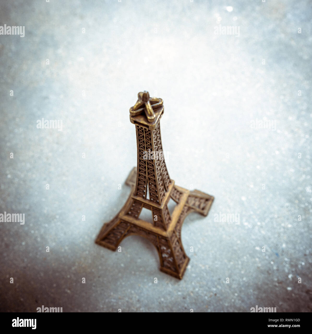 Modèle de souvenirs de la Tour Eiffel sur plancher de béton. Strong vignettage, split effet tonifiant et filtres de grain de film. Banque D'Images