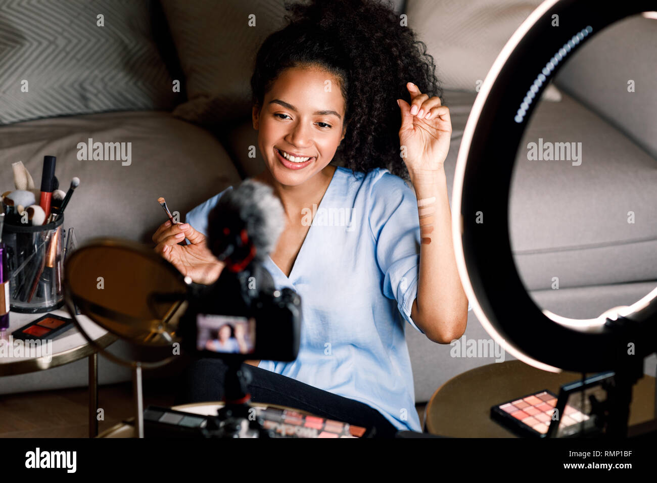 Beauté souriante blogger l'enregistrement vidéo sur appareil photo reflex numérique à partir de la maison Banque D'Images