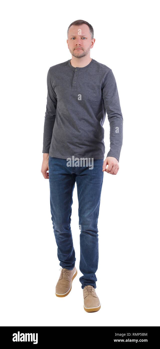 Vue latérale du bel homme va marcher. jeune mec. Plus isolé sur fond blanc. Un homme dans un chandail gris entre dans le cadre. Banque D'Images