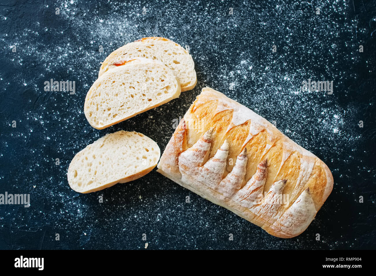 Pain au levain fait maison avec de la farine blanche sur fond noir. Vue d'en haut. Banque D'Images