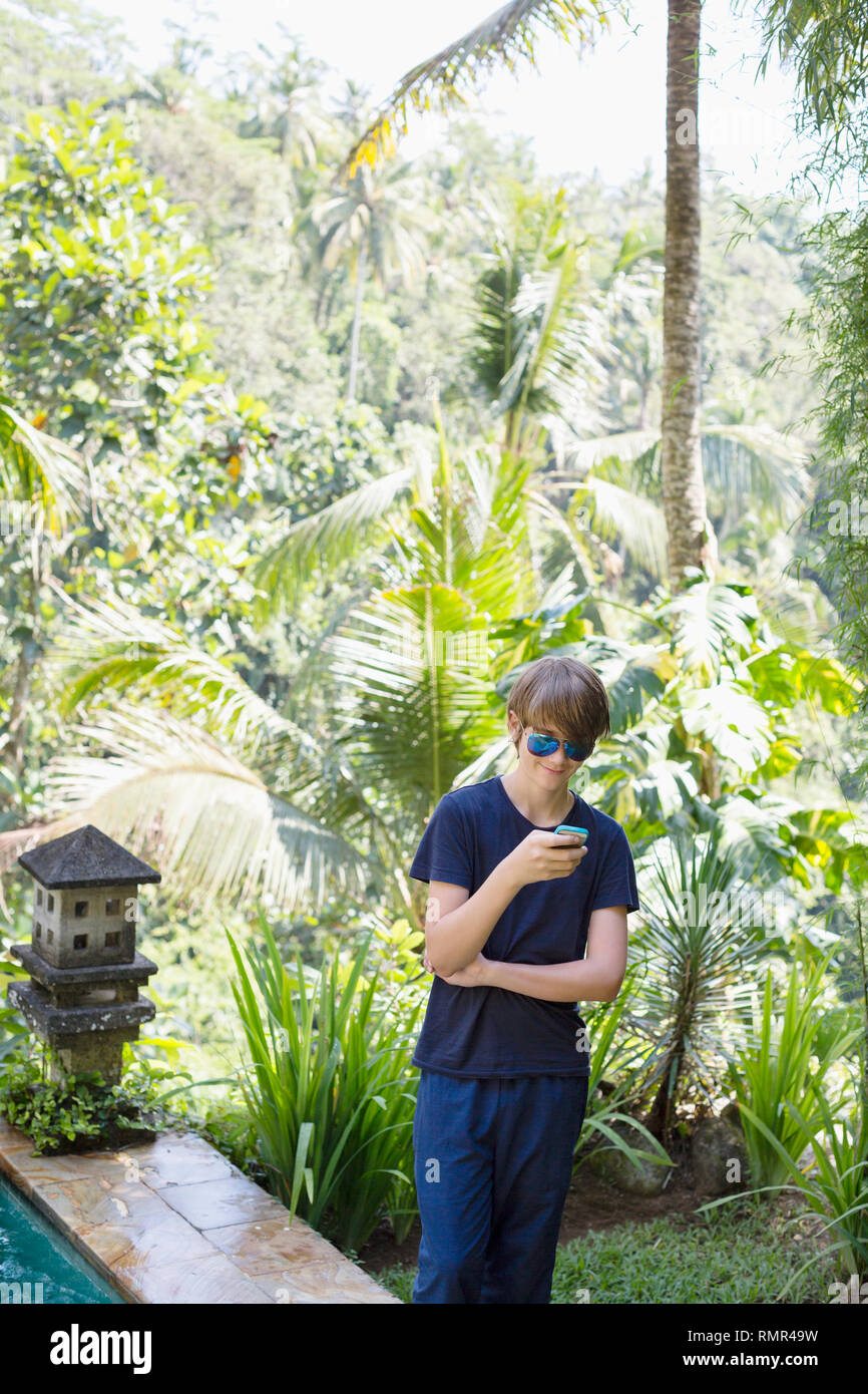 Teenage boy using cell phone Banque D'Images