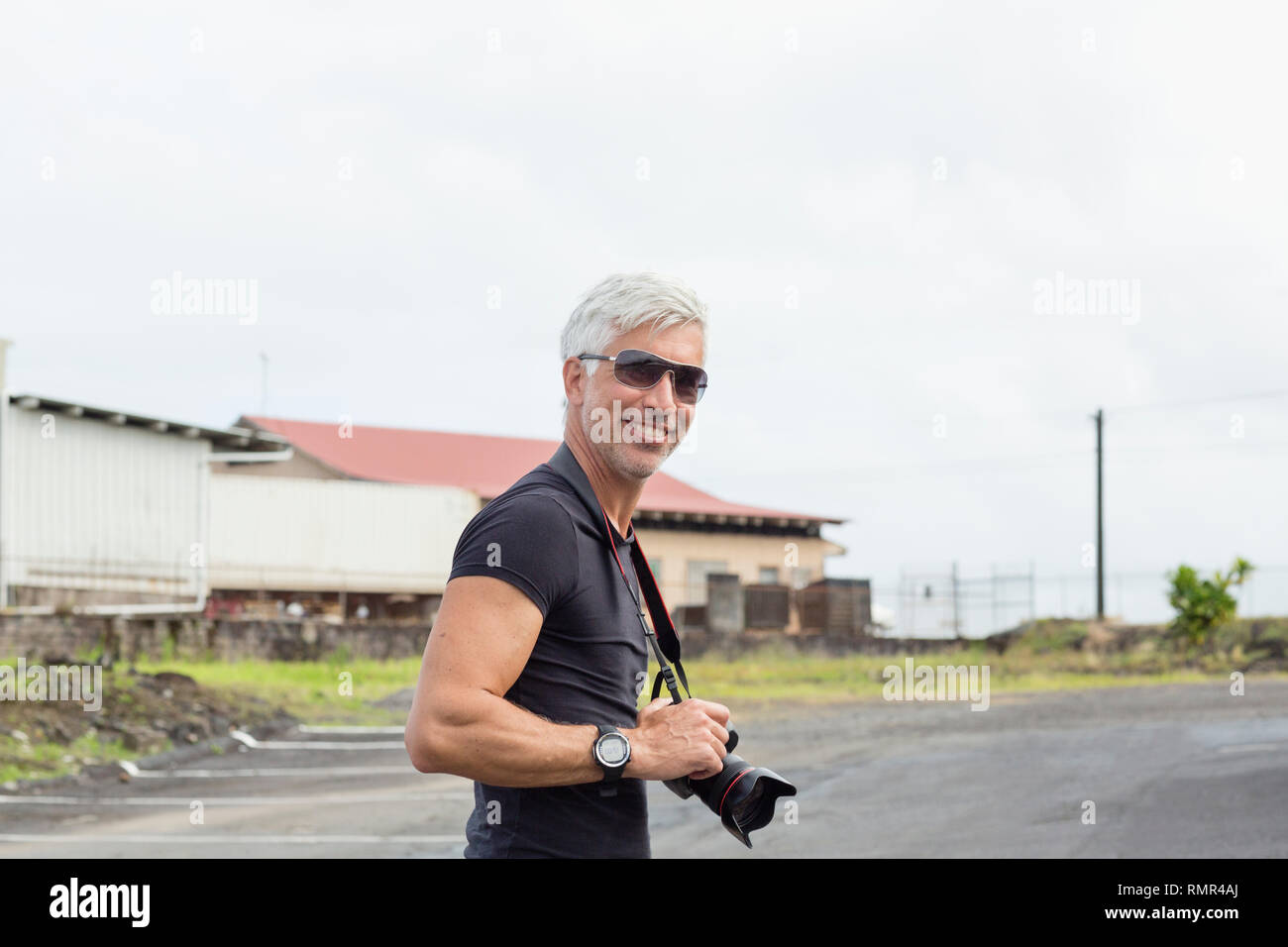 Smiling man holding camera Banque D'Images