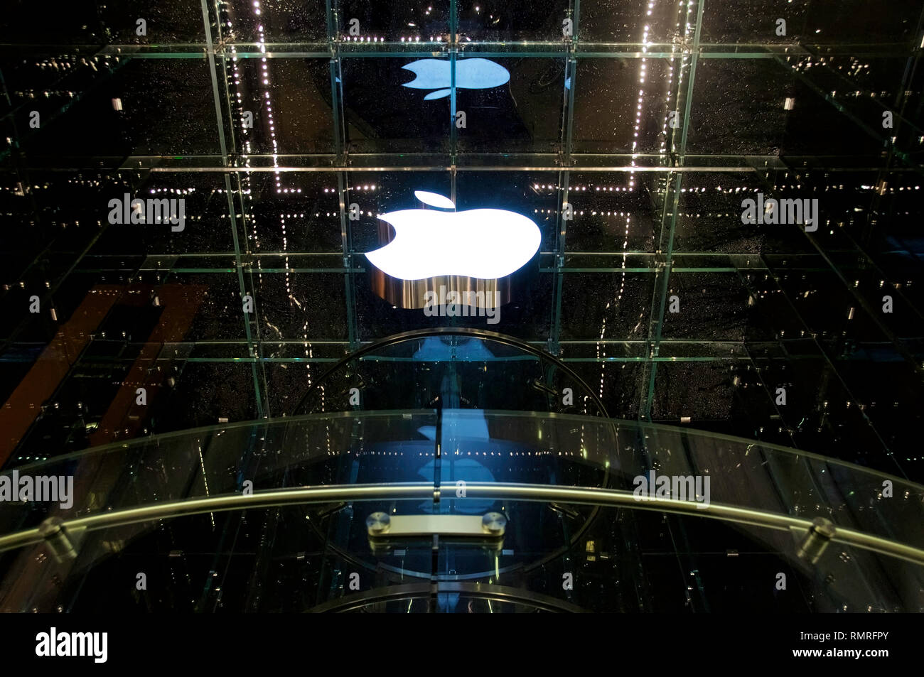 Le logo blanc d'Apple à un magasin phare à New York City's 5th Avenue la nuit. Banque D'Images