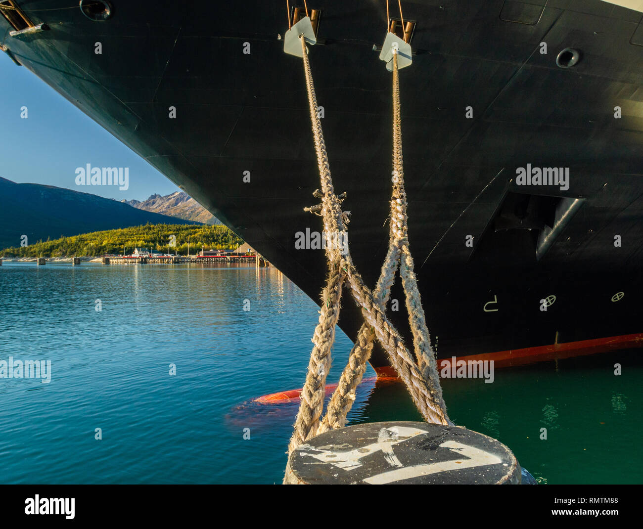 Les amarres avec garde-rats s'étendant de la proue de navire de croisière, liée à la puissance au quai , Skagway en Alaska, USA. Banque D'Images