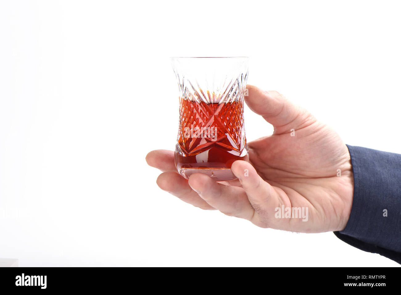 Armud turc en verre avec plateau en main des hommes sur un fond blanc. Close up. Copy space Banque D'Images