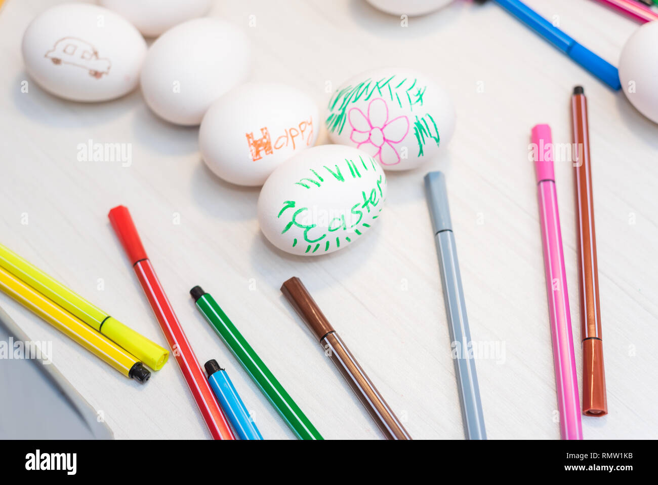 Les oeufs de pâques sont sur la table avec des feutres de couleur.. Idées de Pâques. L'espace pour le texte. Bac d'oeufs Joyeuses Pâques. Banque D'Images