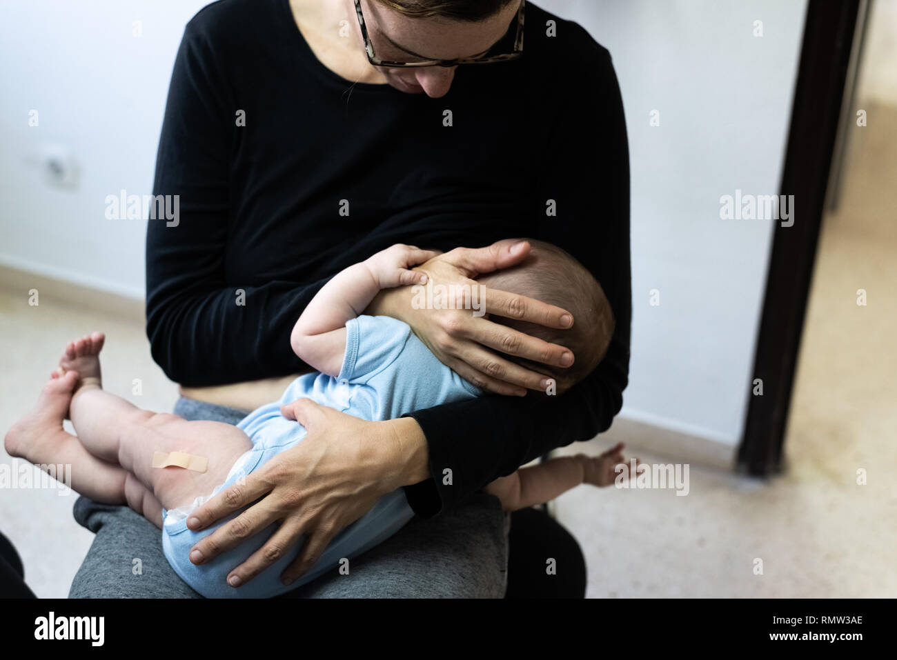 Bebe Qui Pleure Apres La Vaccination Avec L Aide De Bande Ou Le Platre Dans La Cuisse Reconforte Par Sa Mere Qui Allaite Lui Photo Stock Alamy