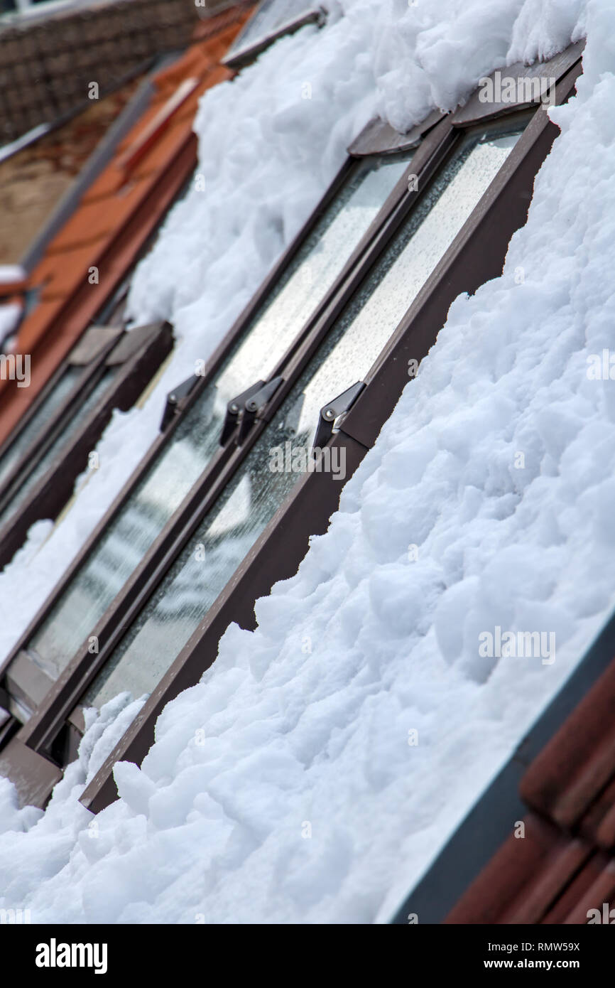 Le toit enneigé avec des fenêtres de la maison. Les toits ouvrants en hiver. Banque D'Images