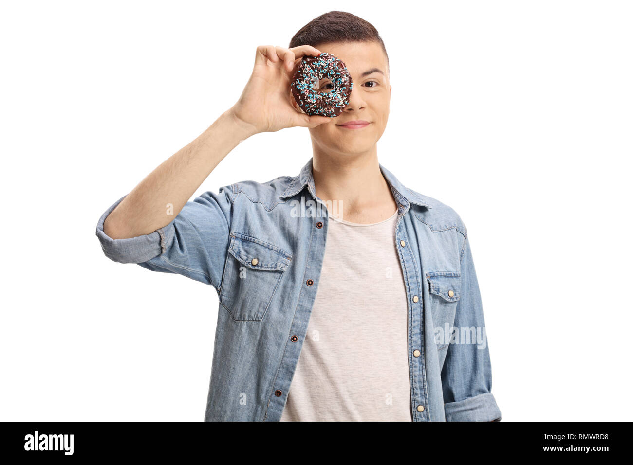 Jeune homme peeking through a donut isolé sur fond blanc Banque D'Images