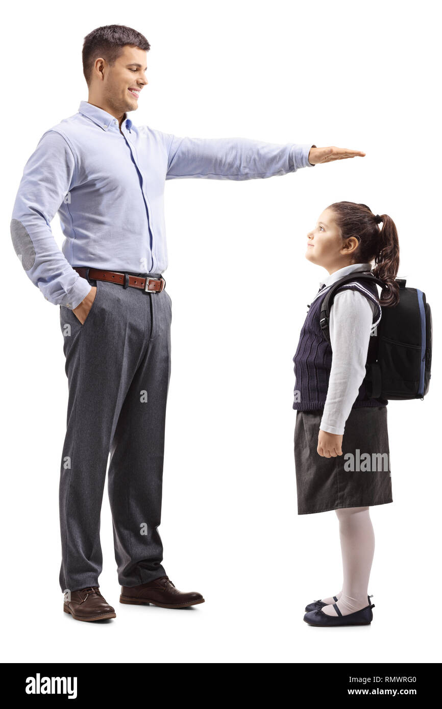Tourné sur toute la longueur d'un jeune homme en faisant signe avec la main clotes formelle et montrant la hauteur d'une écolière peu isolé sur fond blanc Banque D'Images